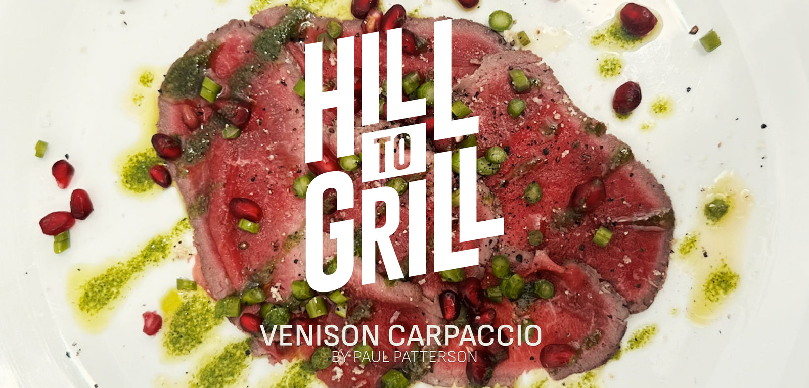 Venison carpaccio with garnishes and a hand slicing it on a wooden board, featuring 'Hill to Grill' branding.