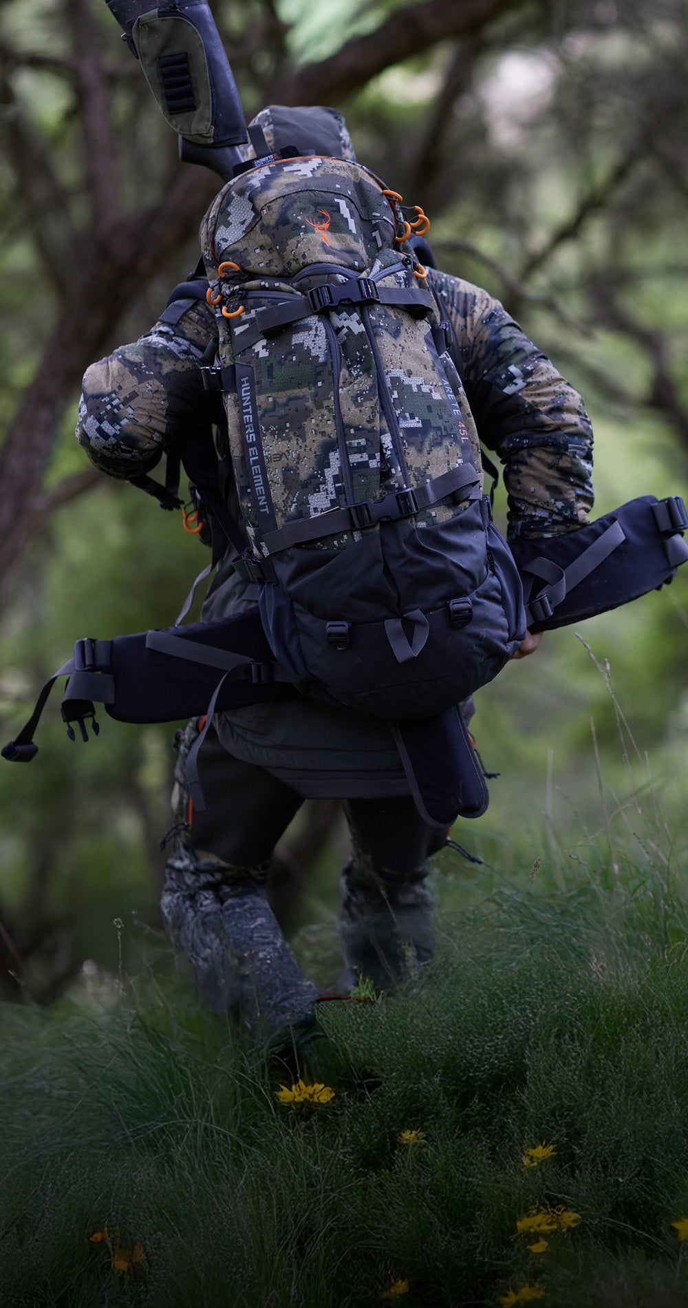 Person in camouflage gear with a backpack in a forest setting